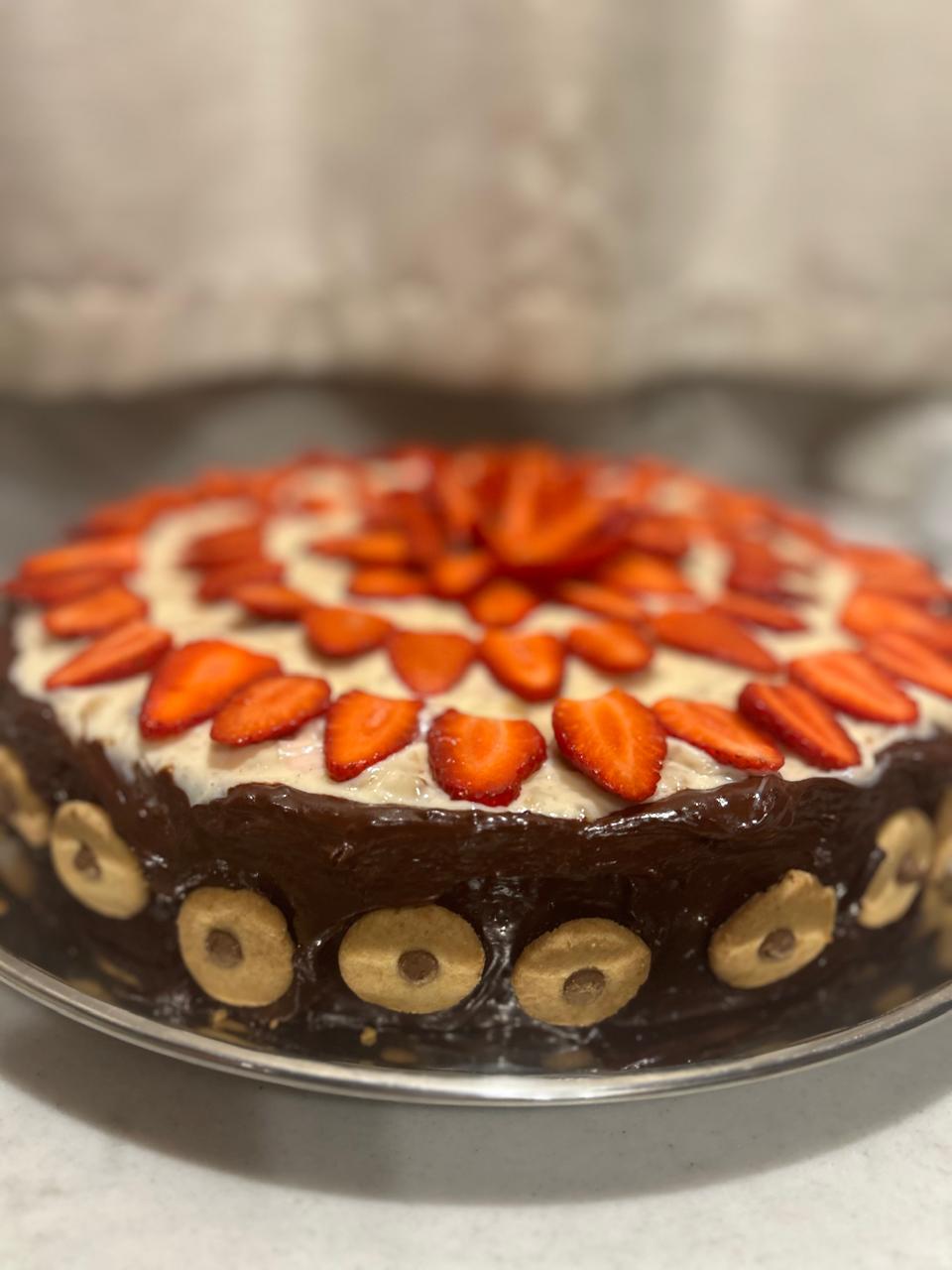 Bolo caseiro de chocolate com morangos servido no retiro